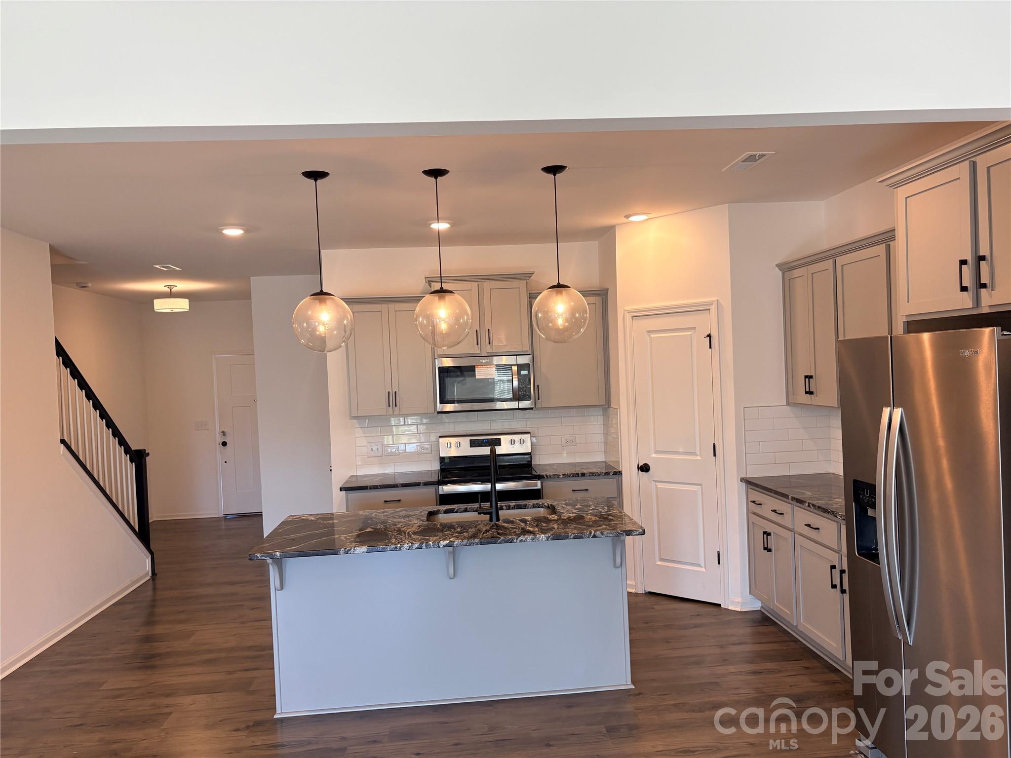 514 Station Street Clover, SC 29710 - Photo 9 of 17 a kitchen with stainless steel appliances kitchen island granite countertop a refrigerator a stove a microwave oven a sink with island and chairs