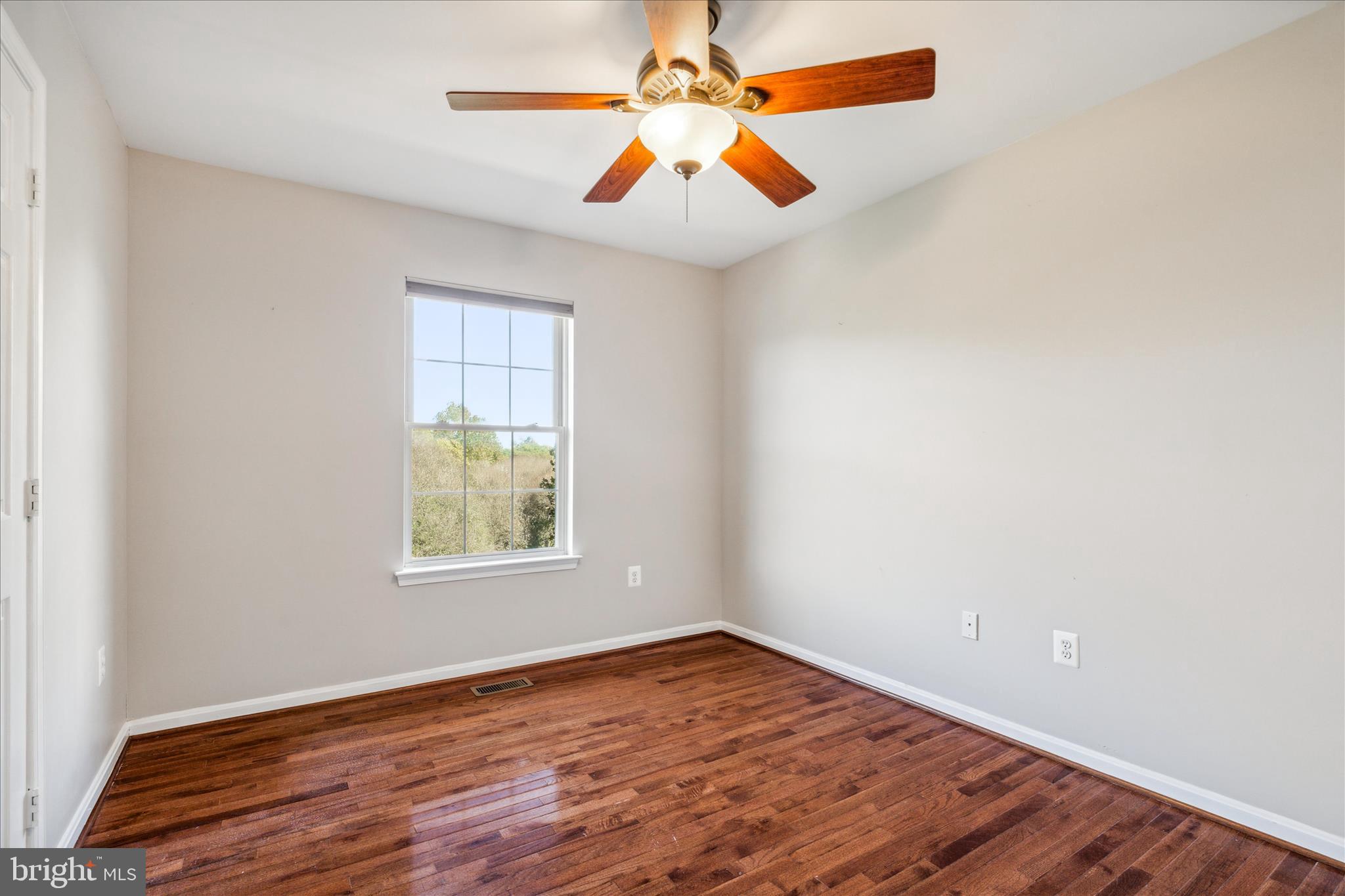 2442 Rippling Brook Road Frederick, MD 21701 - Photo 38 of 85 an empty room with wooden floor and windows