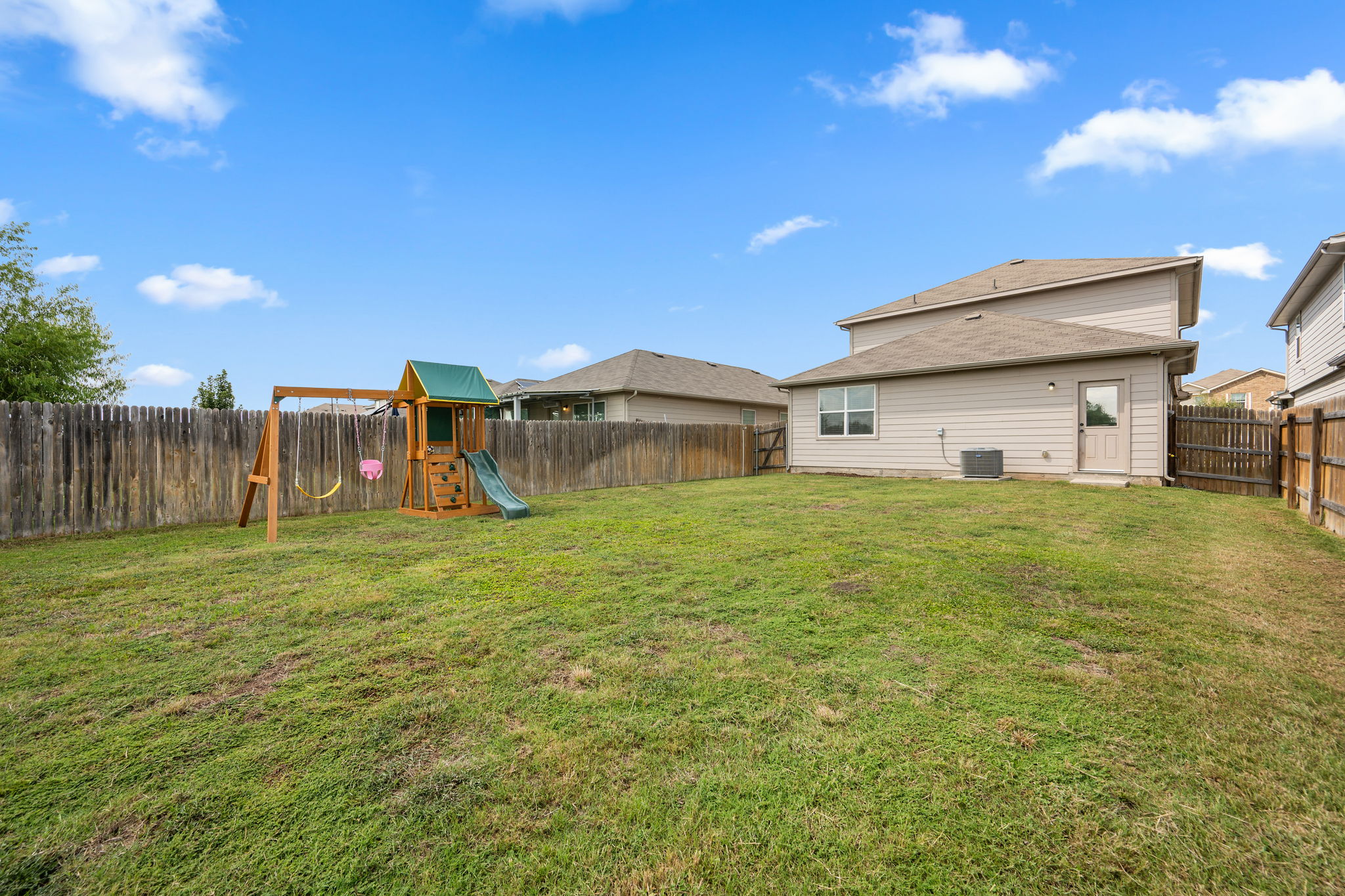 12007 Riprap Drive Manor, TX 78653 - Photo 30 of 37 A spacious backyard provides ample green space for outdoor activities and features a charming playset.