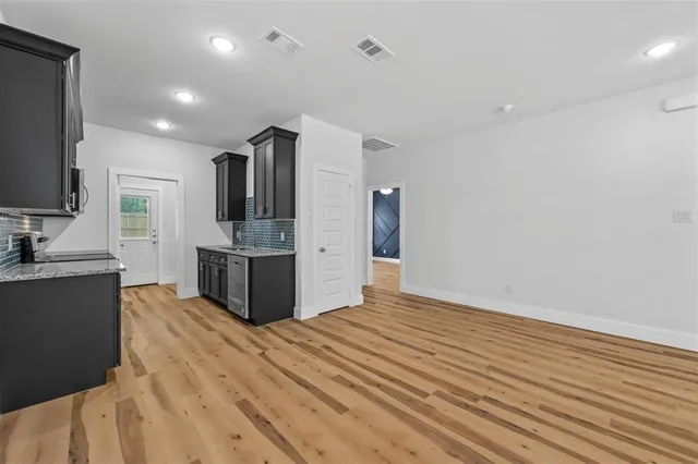 a large kitchen with kitchen island a sink stainless steel appliances and cabinets