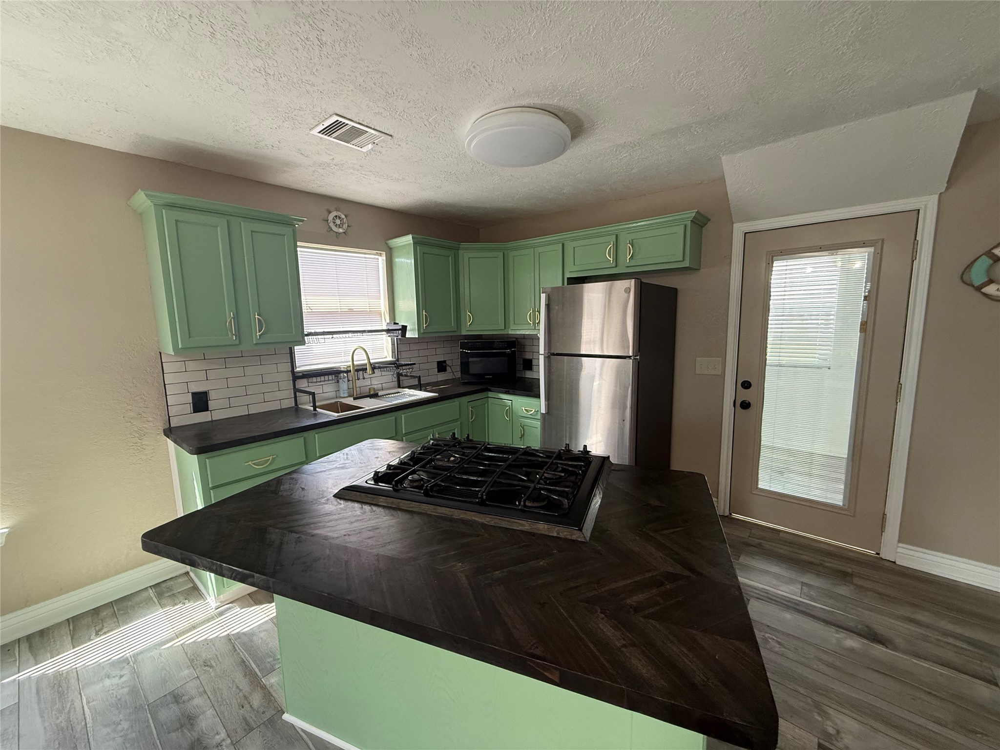 642 5th Street San Leon, TX 77539 - Photo 5 of 10 a kitchen with granite countertop stainless steel appliances a sink stove and refrigerator