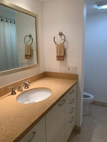 a bathroom with a granite countertop sink and a mirror