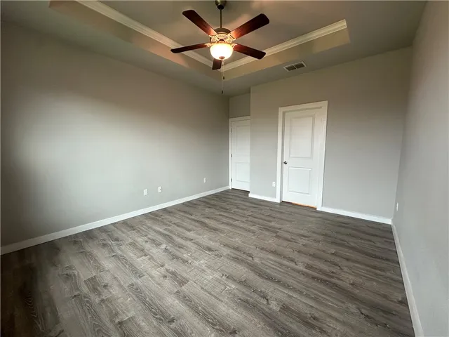 a view of empty room with wooden floor