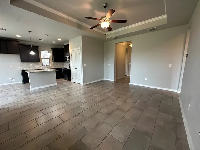 a view of an empty room and kitchen view