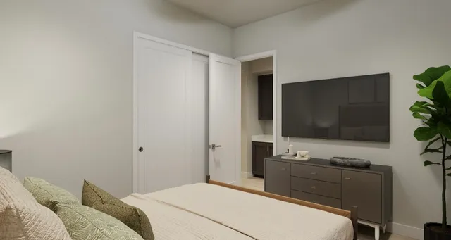 a bedroom with a bed and a flat screen tv