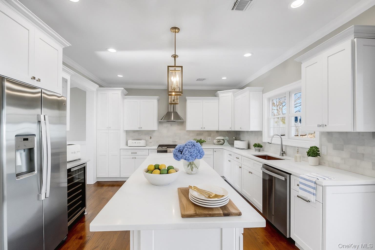 9 Hickory Road Bayville, NY 11709 - Photo 12 of 40 a kitchen with a sink a stove a refrigerator and white cabinets
