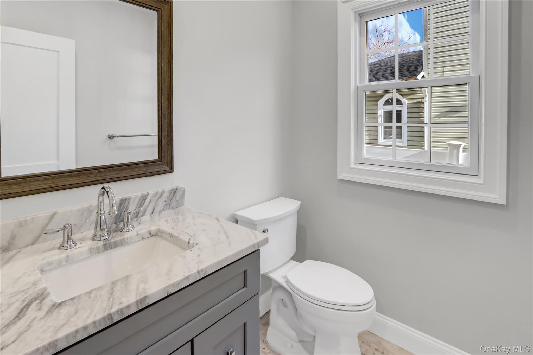 9 Hickory Road Bayville, NY 11709 - Photo 18 of 40 a bathroom with a sink a toilet and mirror