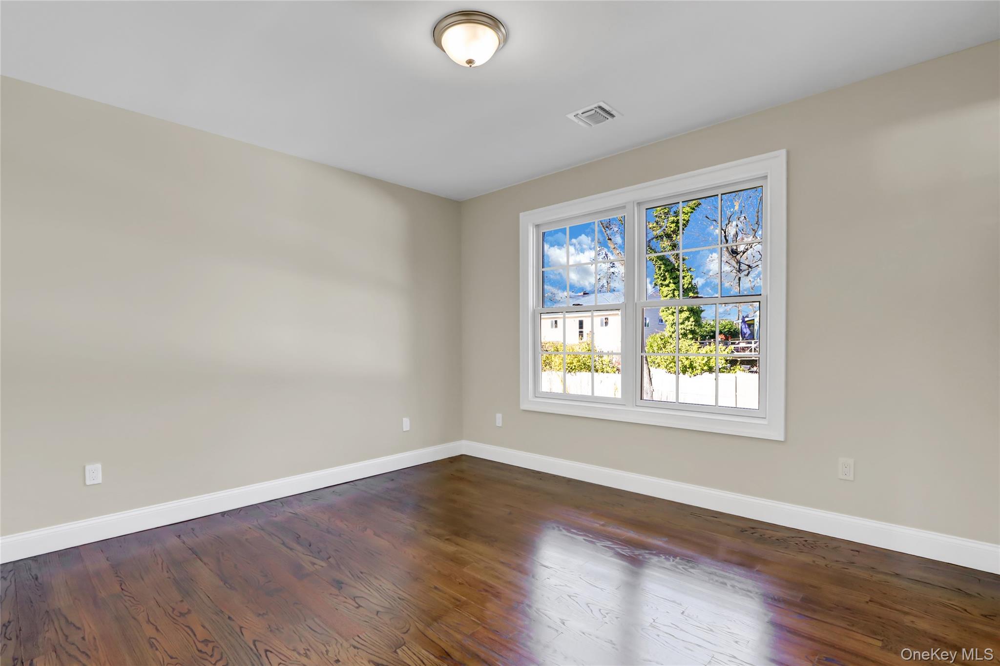 9 Hickory Road Bayville, NY 11709 - Photo 28 of 40 an empty room with wooden floor and window