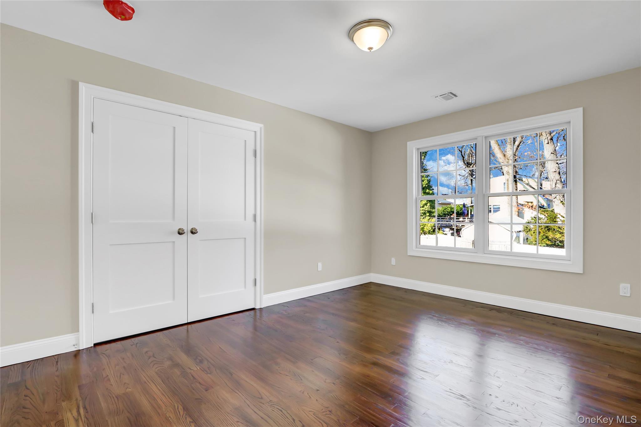 9 Hickory Road Bayville, NY 11709 - Photo 30 of 40 an empty room with wooden floor and windows