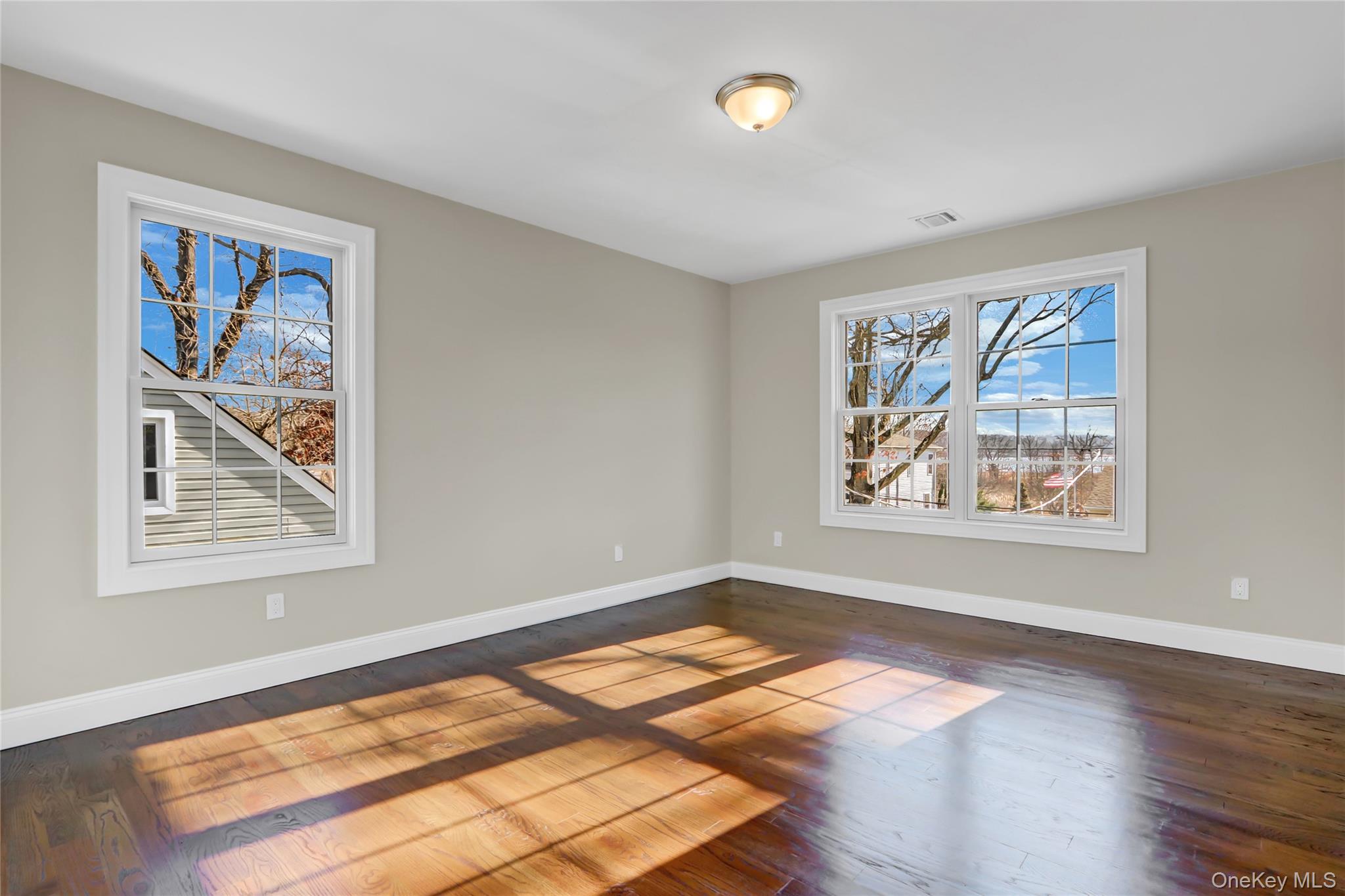 9 Hickory Road Bayville, NY 11709 - Photo 32 of 40 a view of an empty room with window and wooden floor