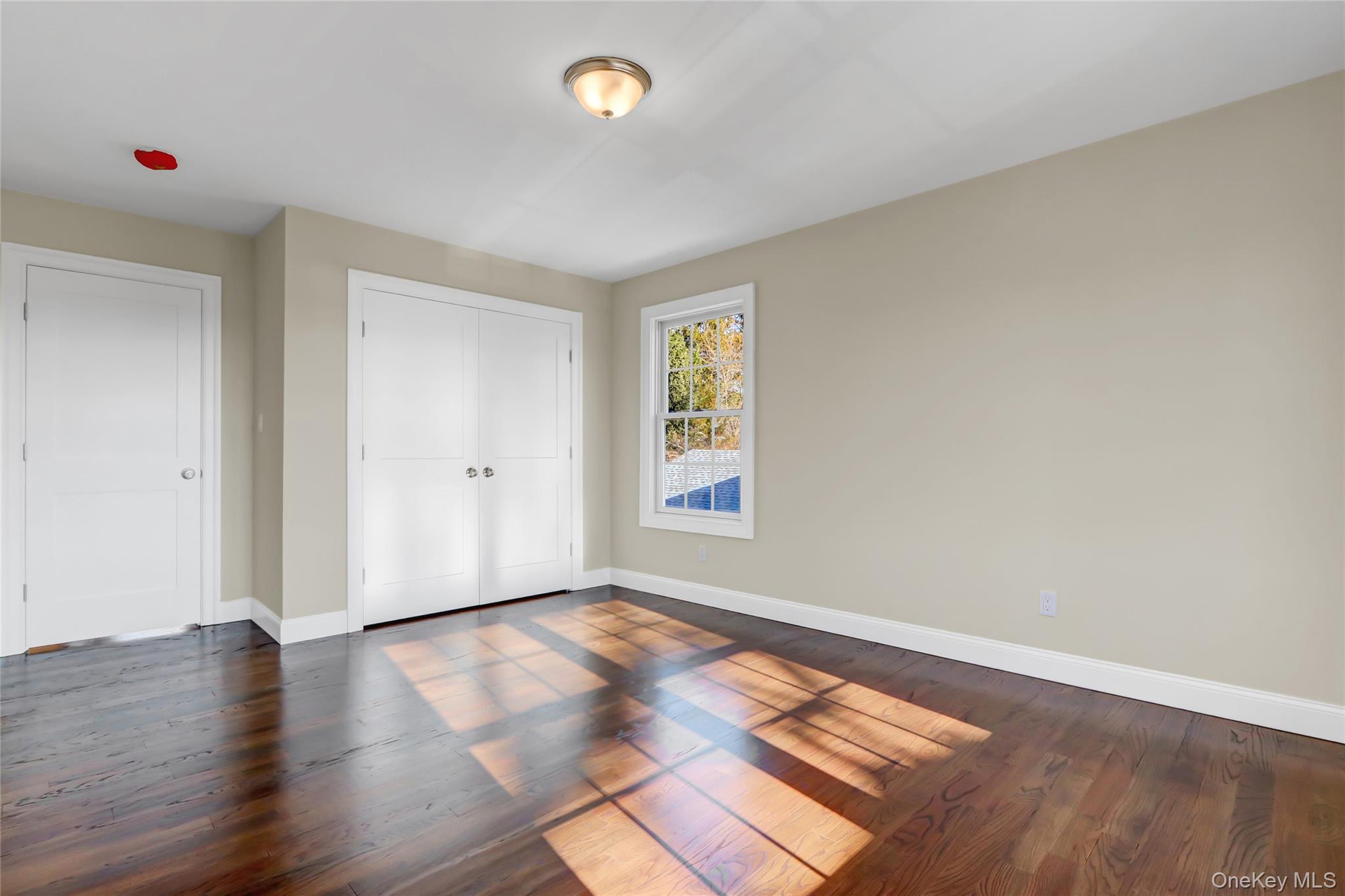9 Hickory Road Bayville, NY 11709 - Photo 33 of 40 an empty room with wooden floor and windows
