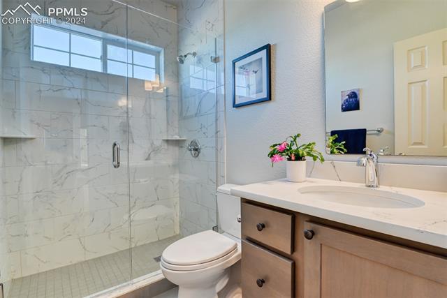 19410 Enoch Road Colorado Springs, CO 80930 - Photo 18 of 44 Bathroom with walk in shower, toilet, and oversized vanity