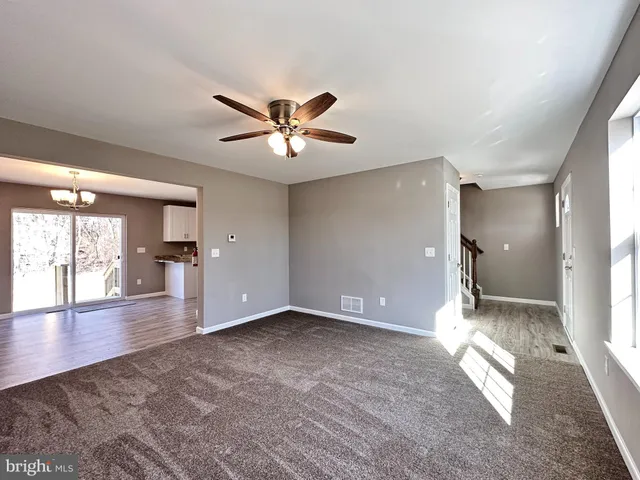 a view of empty room with wooden floor and a window