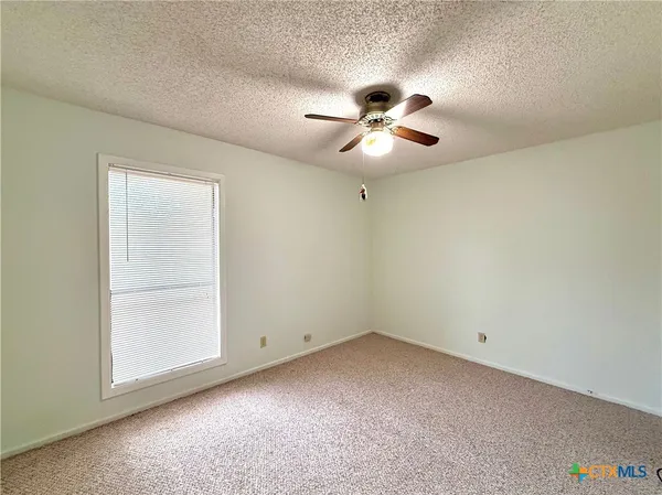 a view of room with a ceiling fan and a window