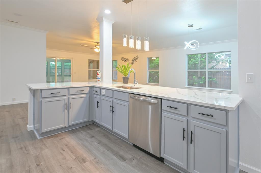 910 Rocking Spur Cove Pflugerville, TX 78660 - Photo 5 of 17 A streamlined kitchen island with a gleaming sink anchors this bright, open-concept living space.