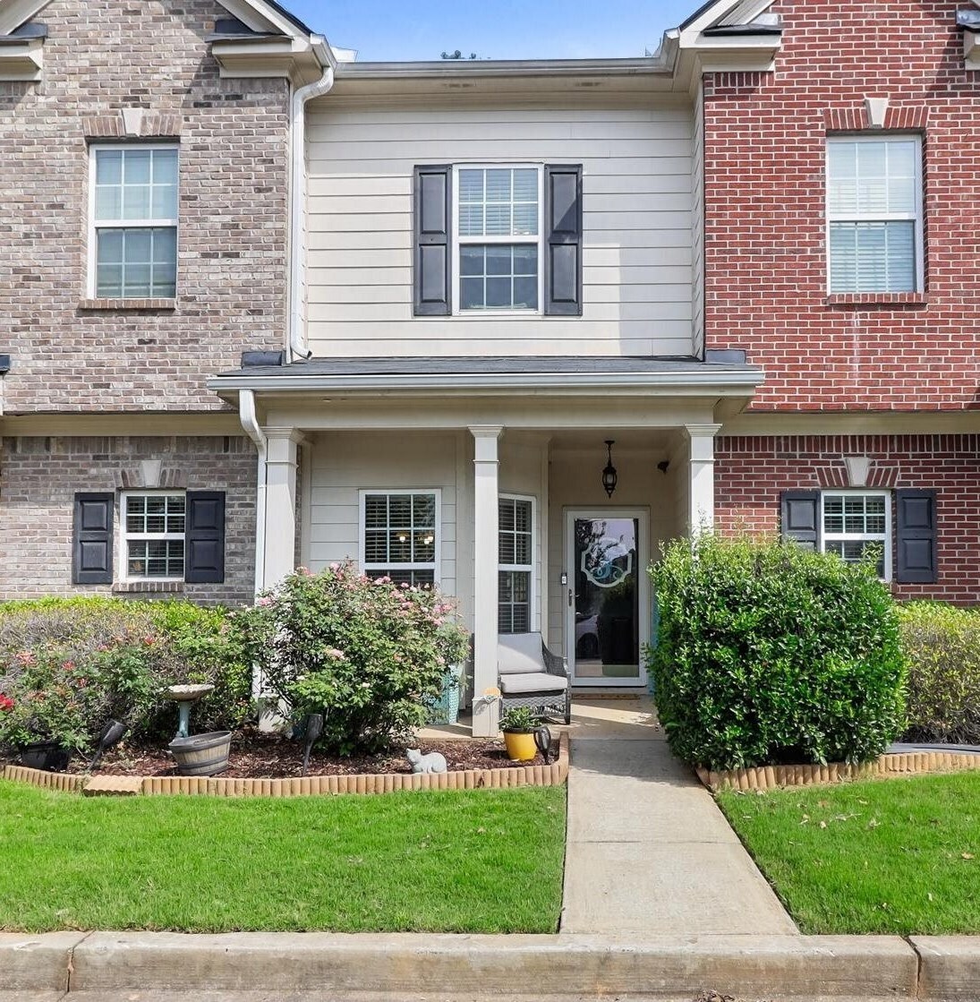 front view of a brick house with a yard