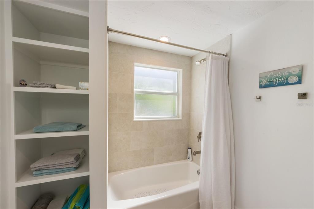413 Poinsettia Road Anna Maria, FL 34216 - Photo 20 of 60 a bathroom with a tub a window and a shower