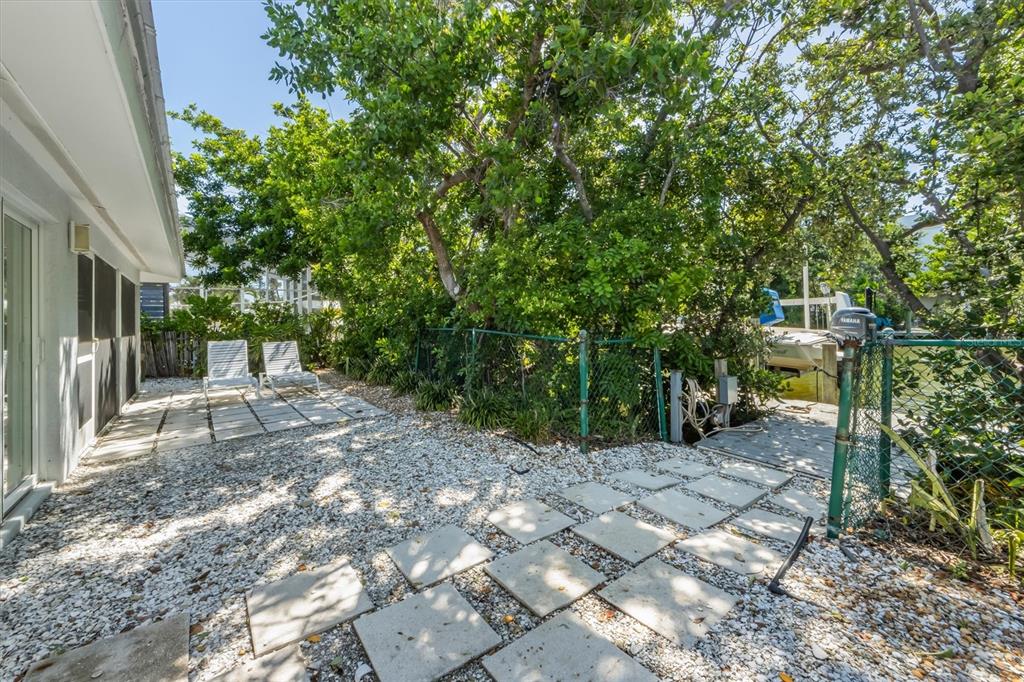 413 Poinsettia Road Anna Maria, FL 34216 - Photo 25 of 60 a view of a yard with plants and trees
