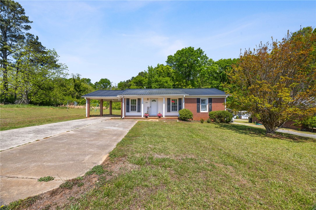 309 East Hampton Avenue Honea Path, SC 29654 - Photo 2 of 23 This charming home offers a welcoming facade with a classic brick and siding exterior.