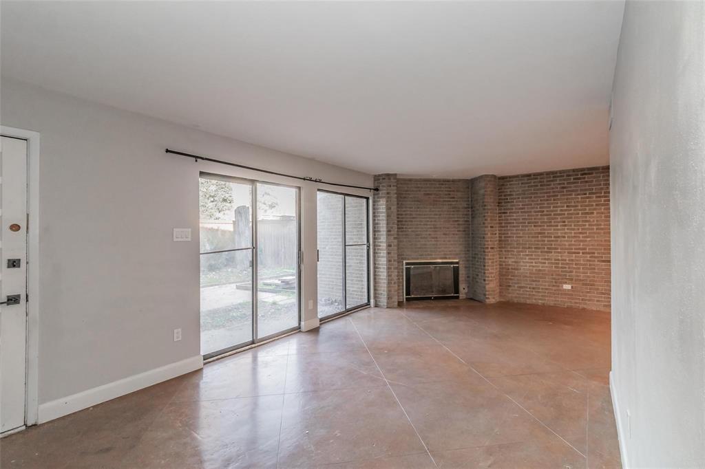 4930 Thunder Road Dallas, TX 75244 - Photo 9 of 23 Spacious living area featuring a brick fireplace, sliding glass doors, and durable tile flooring