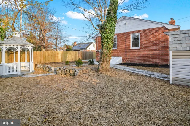 a view of a white house with a yard and large tree