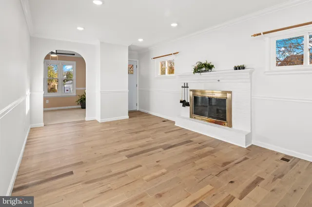 a view of a livingroom with wooden floor and a fireplace