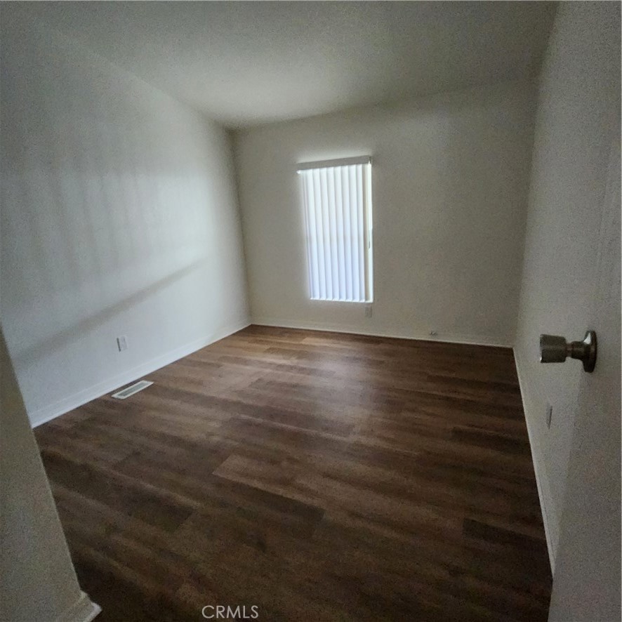 20843 Waalew Road, Unit C136 Apple Valley, CA 92307 - Photo 22 of 39 a view of an empty room with wooden floor and a window