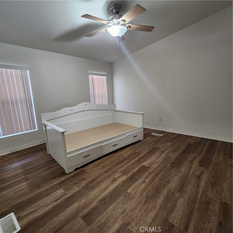 20843 Waalew Road, Unit C136 Apple Valley, CA 92307 - Photo 23 of 39 a spacious bedroom with a bed and a chandelier