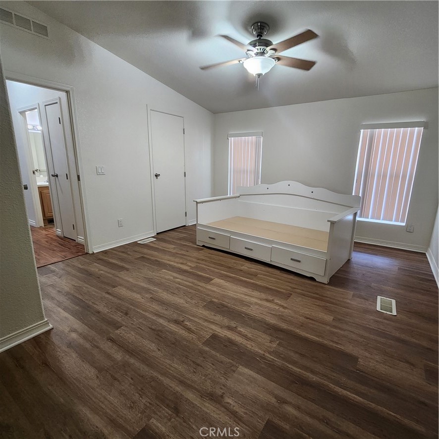 20843 Waalew Road, Unit C136 Apple Valley, CA 92307 - Photo 24 of 39 a spacious bedroom with a bed and a chandelier