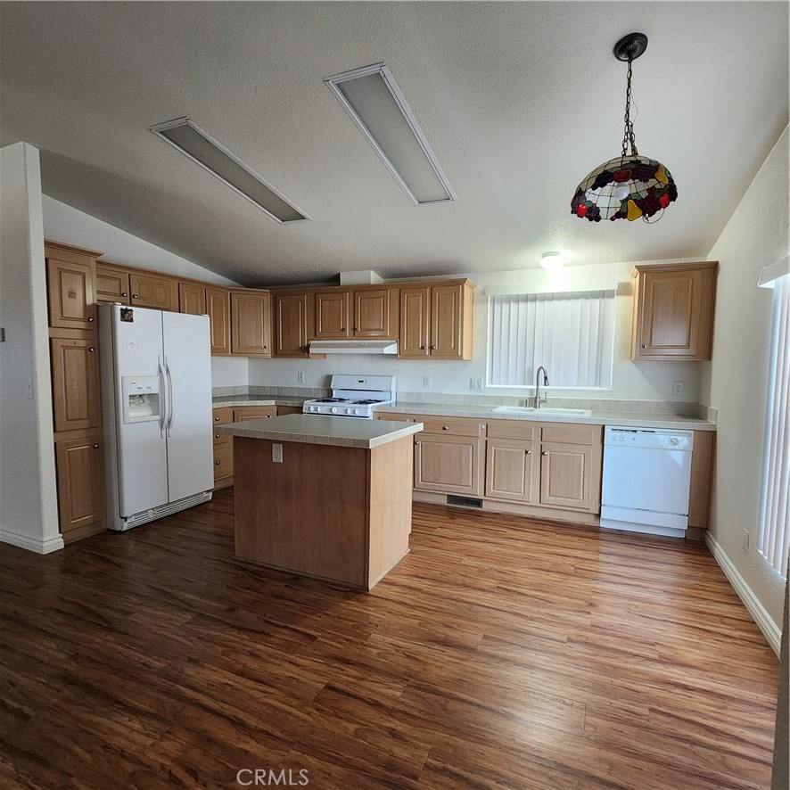 20843 Waalew Road, Unit C136 Apple Valley, CA 92307 - Photo 10 of 39 a kitchen with stainless steel appliances granite countertop a sink a stove a refrigerator and island with wooden floor