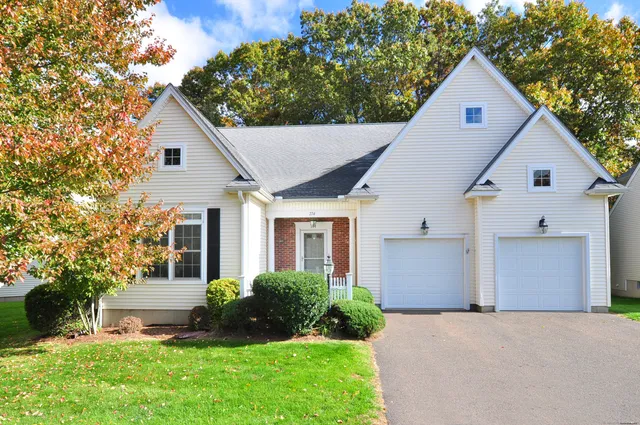a view of a yard in front of a house with plants and large tree