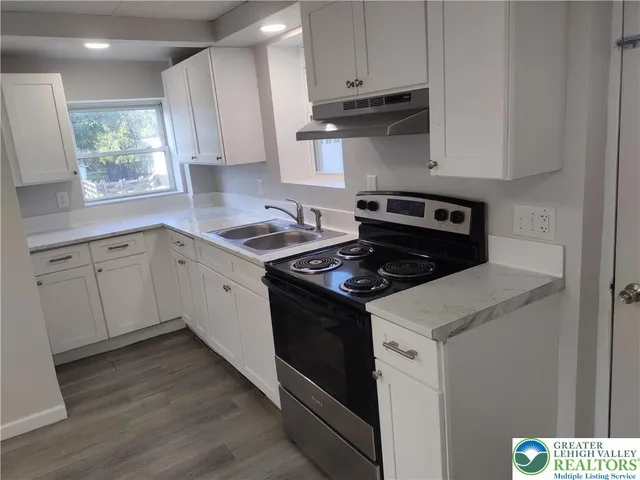 a kitchen with a stove and a white cabinets