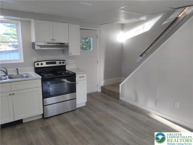 a kitchen with wooden floors and appliances