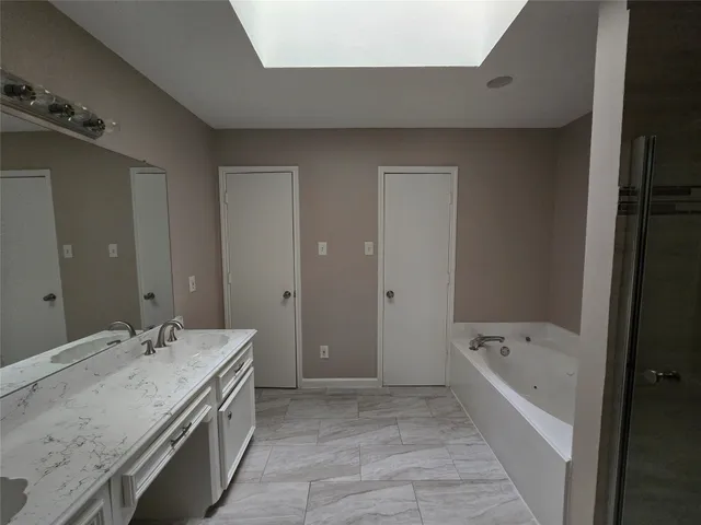 a bathroom with a tub a sink and mirror