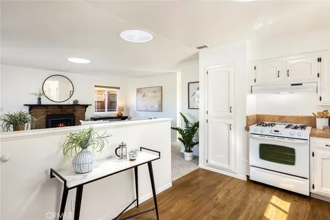a kitchen with granite countertop white cabinets and white appliances