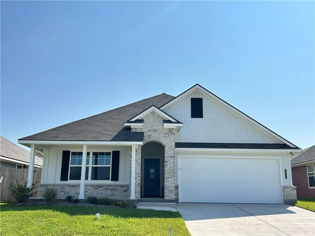 a front view of a house with yard and green space