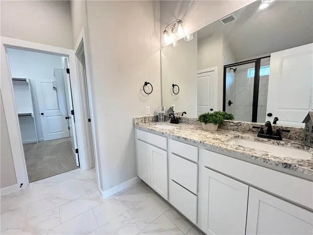 a bathroom with a granite countertop sink and a mirror