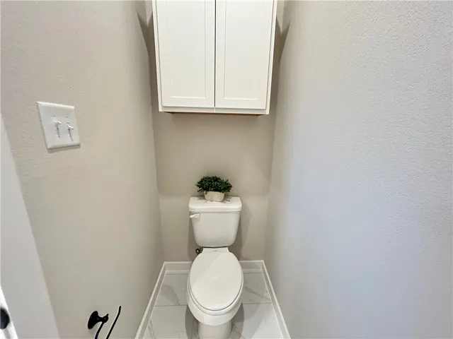 a white toilet sitting next to a white cabinet