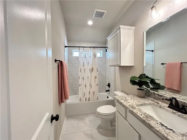 a bathroom with a granite countertop sink toilet and shower