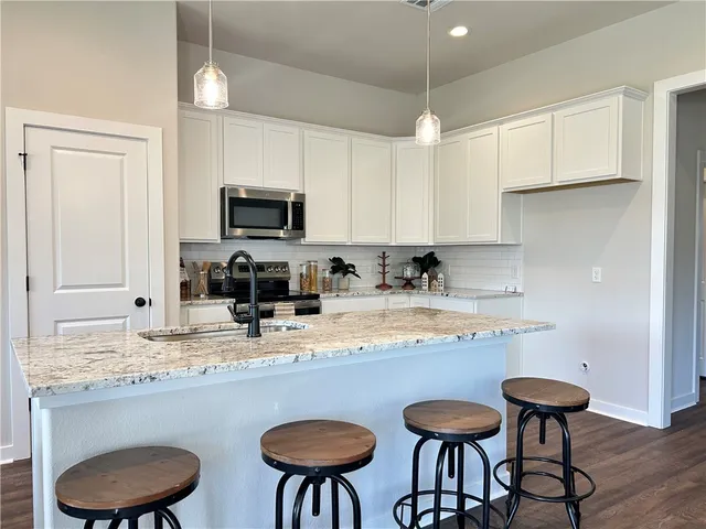 a kitchen with granite countertop a sink and a stove