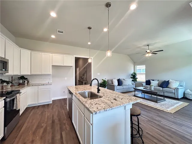 a kitchen with granite countertop a stove and a refrigerator