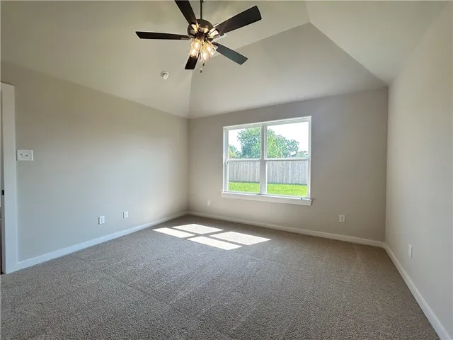 an empty room with windows and ceiling fan