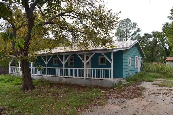 a view of a house with a yard and fence