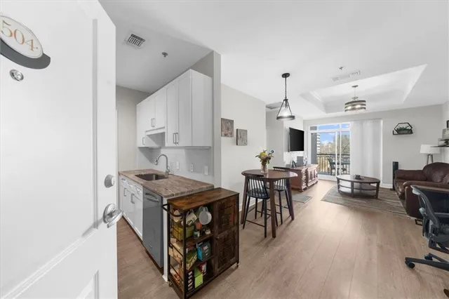 a living room with furniture a dining table and chairs with wooden floor