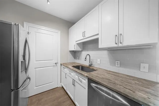 a kitchen with stainless steel appliances granite countertop a refrigerator sink and cabinets