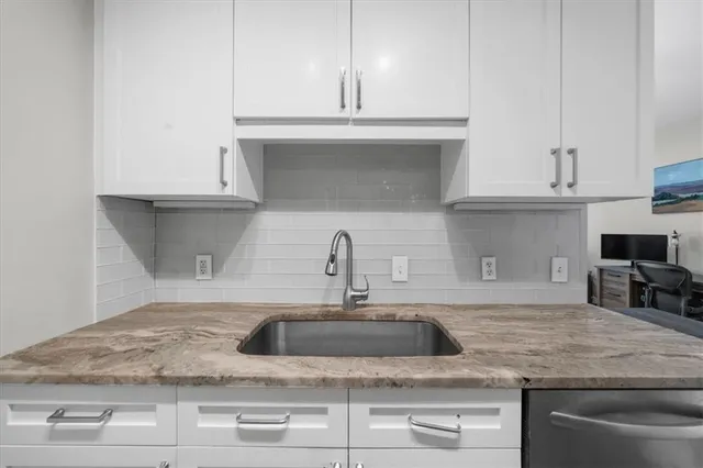 a kitchen with granite countertop a sink and a stove