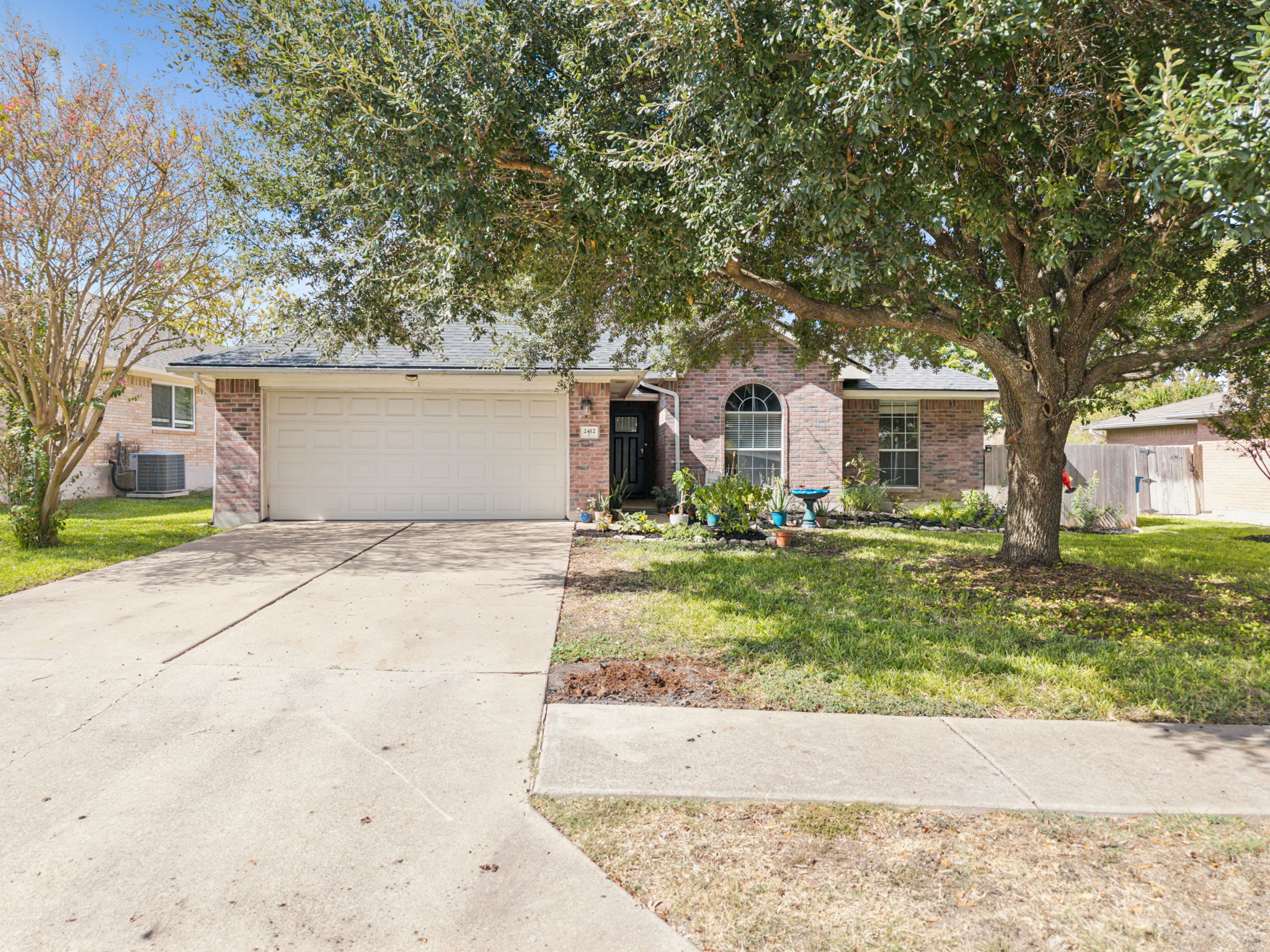 2412 Chestnut Path Round Rock, TX 78664 - Photo 1 of 26 Mature trees shade this charming brick residence with a prominent garage and inviting entry.