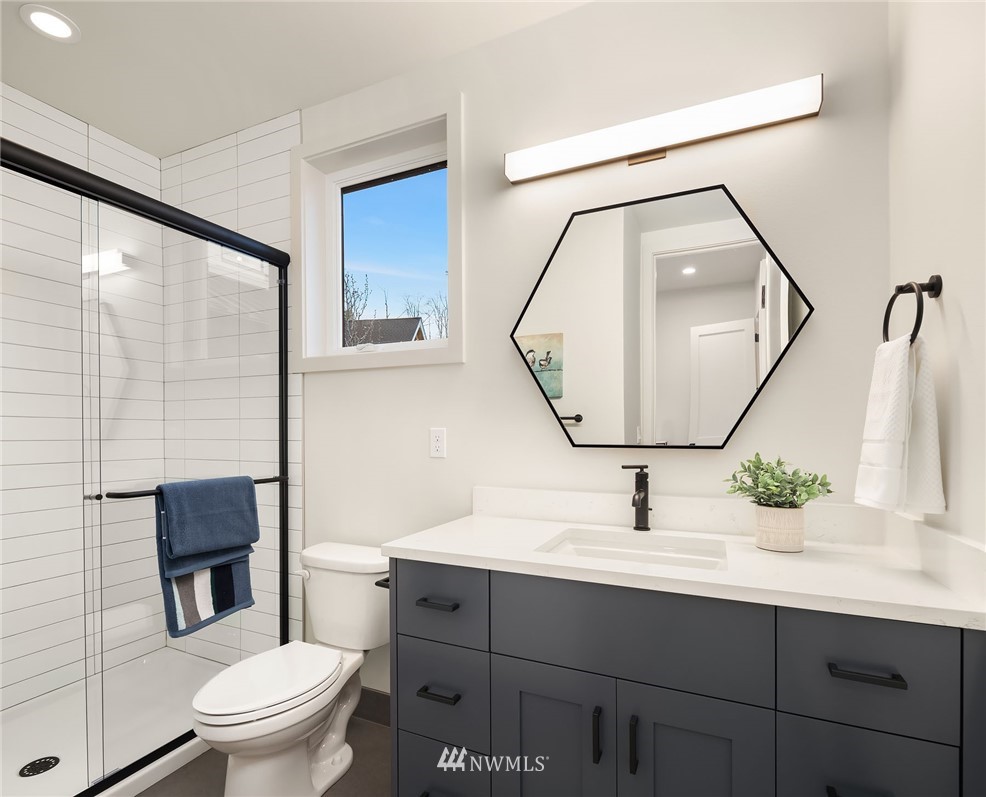 23517 7th Avenue Southeast Bothell, WA 98021 - Photo 24 of 32 a bathroom with a toilet a sink a mirror a vanity and shower