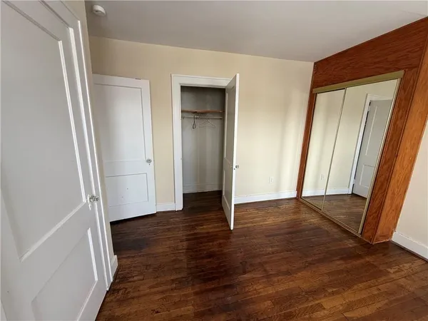 an empty room with wooden floor and closet