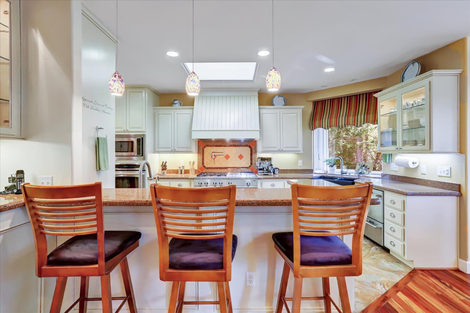 10973 Scotts Flat Dam Road Nevada City, CA 95959 - Photo 19 of 91 a kitchen with stainless steel appliances granite countertop wooden floor a dining table and chairs